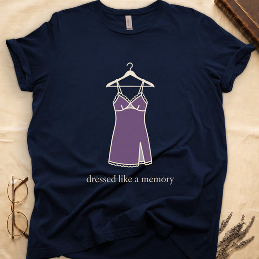 Navy tee with dusty plum slip dress on cream hanger and "dressed like a memory" in lowercase cream serif below.