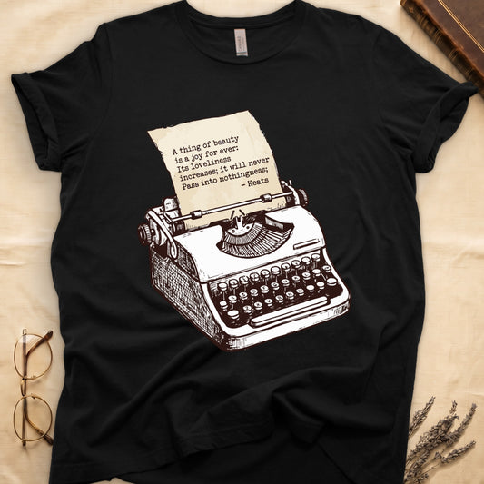 Black tee with vintage typewriter in cream linework, paper showing "A thing of beauty is a joy for ever" by Keats.