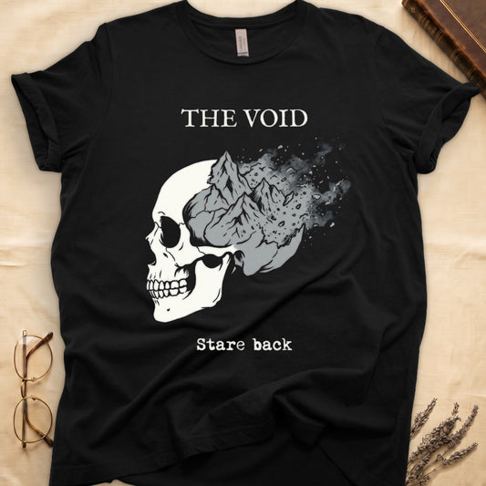 Black tee with skull eroding into mountain landscape and stardust, "THE VOID" top, "Stare back" typewriter below.
