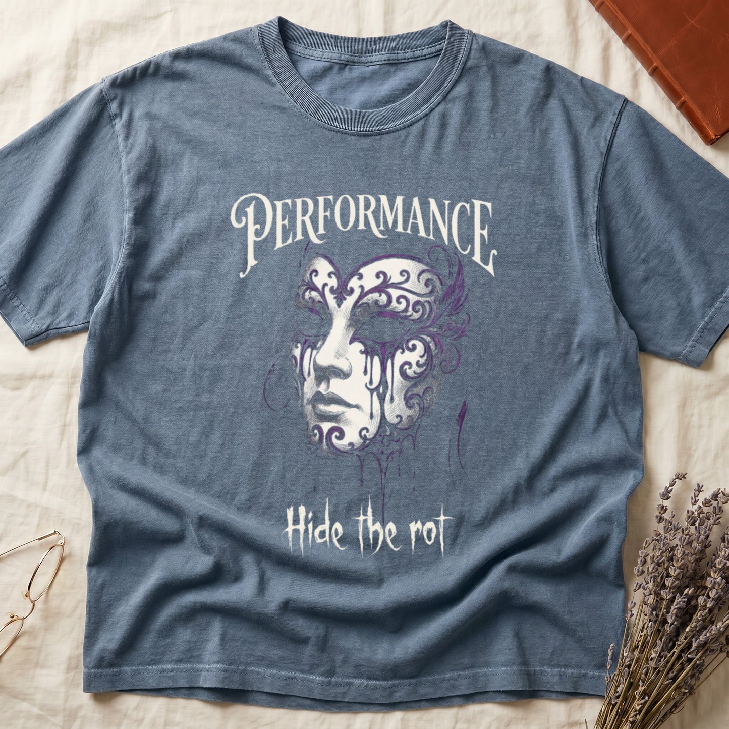Blue Jean tee with ornate Venetian mask in cream and purple filigree dripping ink, "PERFORMANCE" top, "Hide the rot" below.