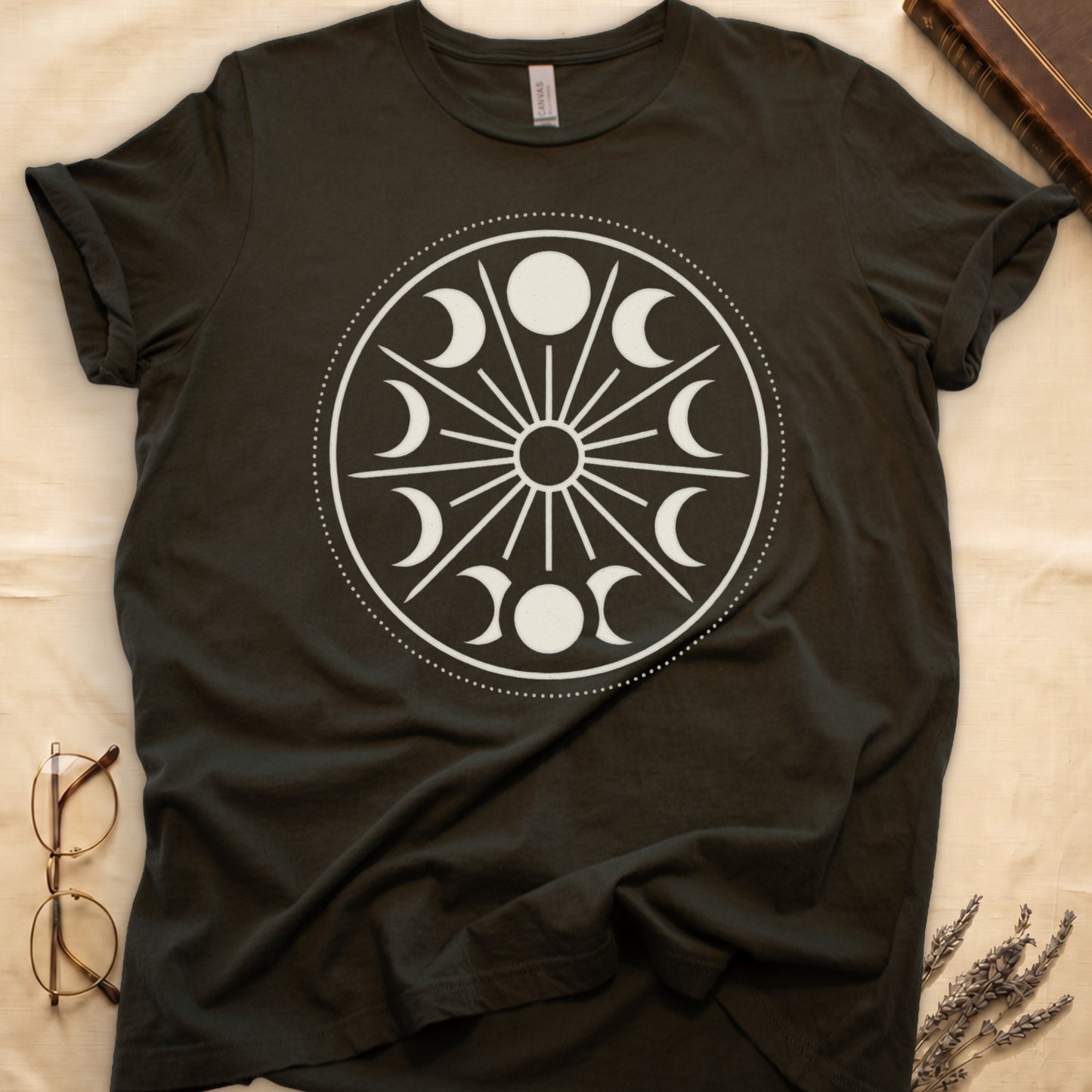 Military Green tee with cream lunar orrery wheel, dotted ring, radial sunburst, moon phases around perimeter, central star.
