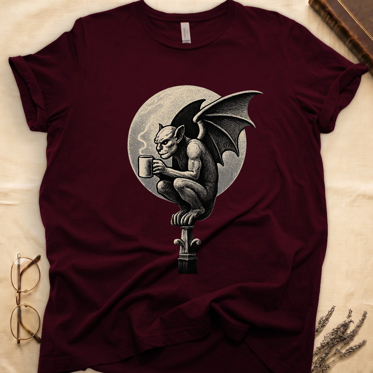 Maroon tee with gargoyle on stone pinnacle holding coffee mug, cream-parchment full moon behind, engraving style.
