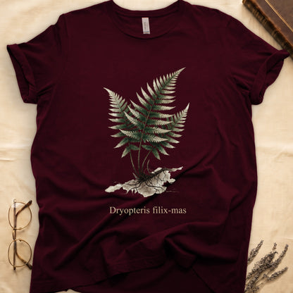 Maroon tee with Victorian fern illustration of Dryopteris filix-mas in greens with exposed root, italic Latin binomial below.