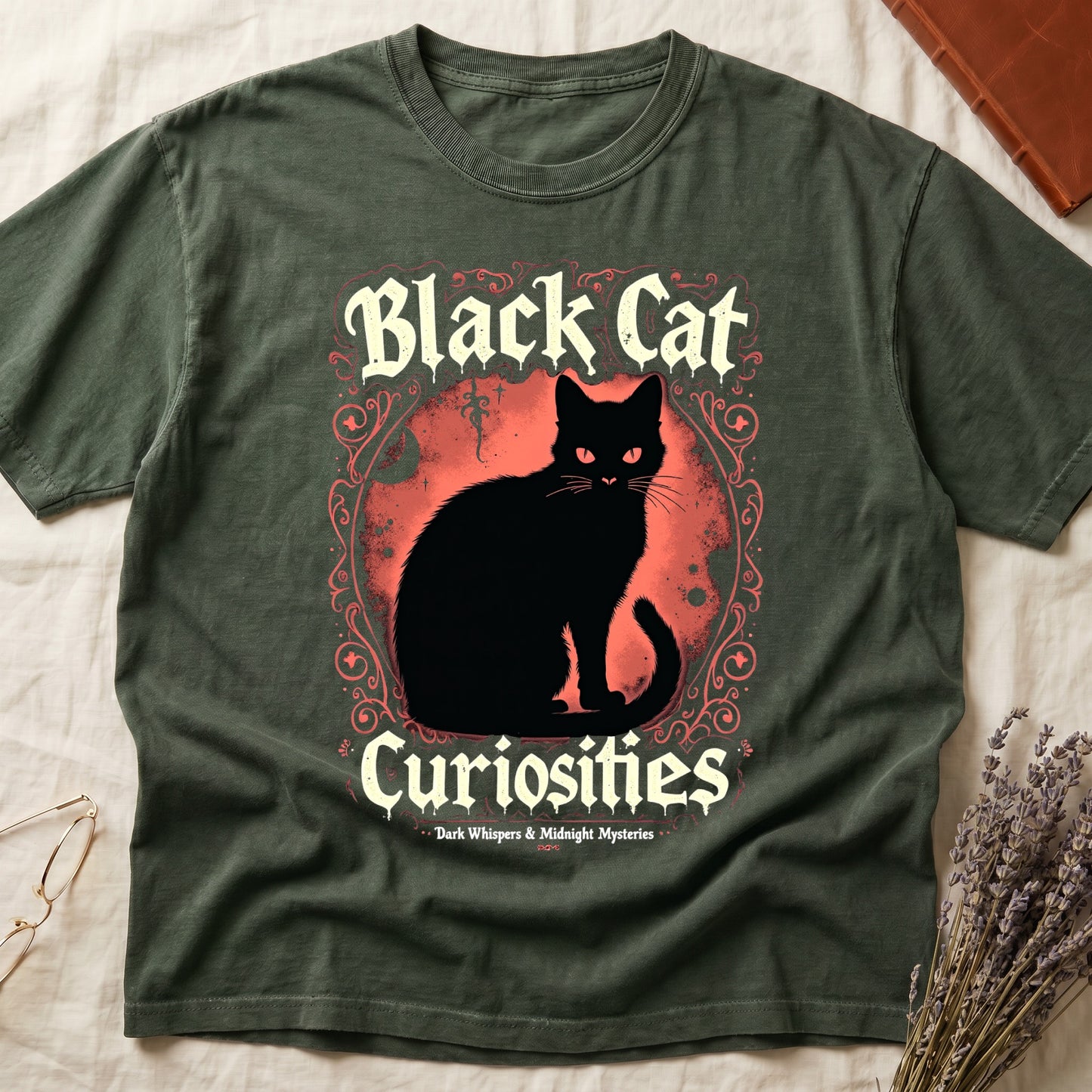 Green tee with black cat, red eyes, red-orange moon, "Black Cat Curiosities," "Dark Whispers & Midnight Mysteries."
