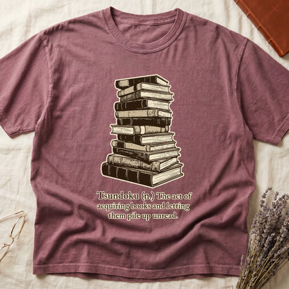 Dark Rose tee with stack of vintage hardcovers, "Tsundoku (n.) The act of acquiring books and letting them pile up unread."