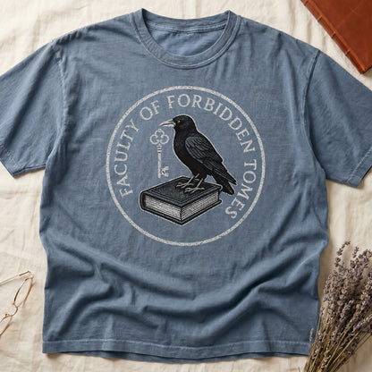 Espresso tee with circular badge, raven on closed book holding key, "FACULTY OF FORBIDDEN TOMES" curved around in cream.