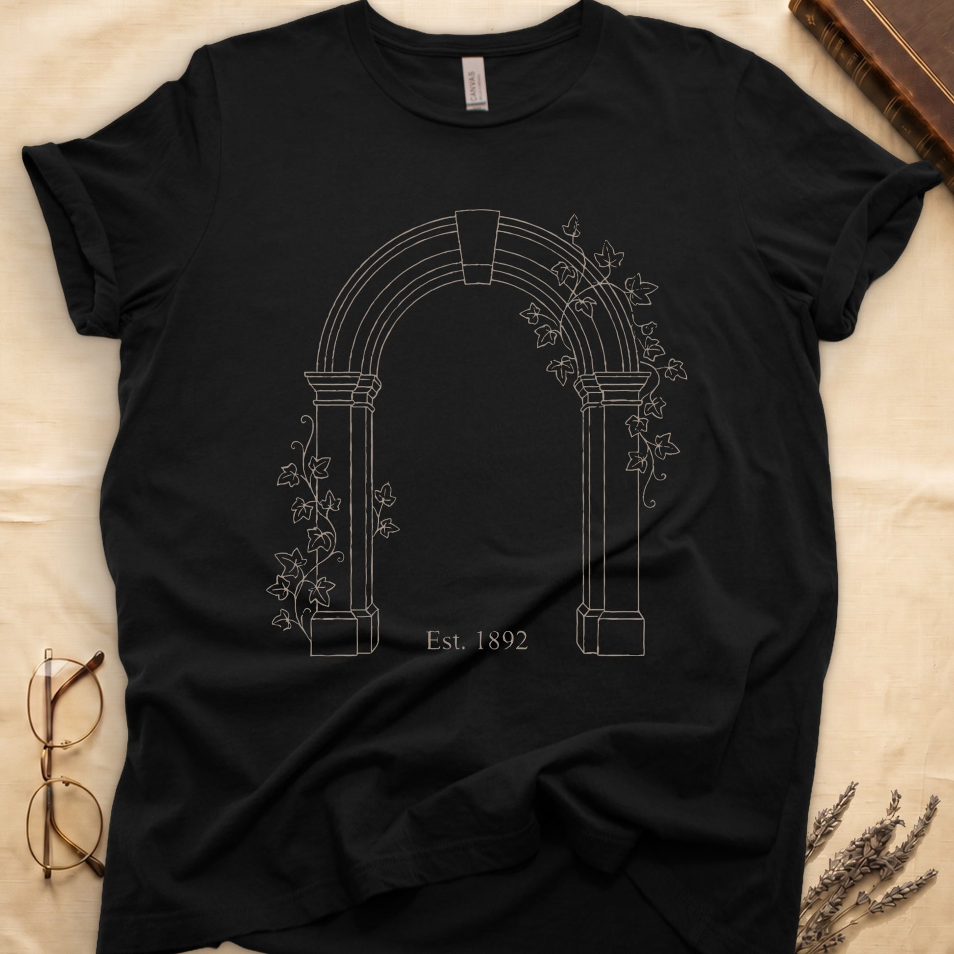 Black tee with Gothic stone archway in cream linework, ivy climbing the columns, "Est. 1892" inscribed at the base.