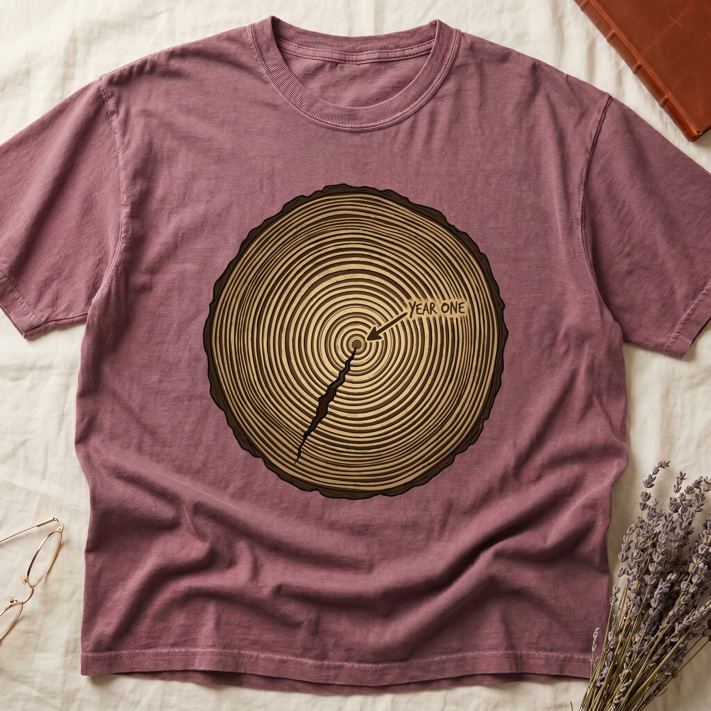 Dark Rose tee with cross-section of tree rings in warm brown, arrow pointing to center labeled "YEAR ONE" in serif type.
