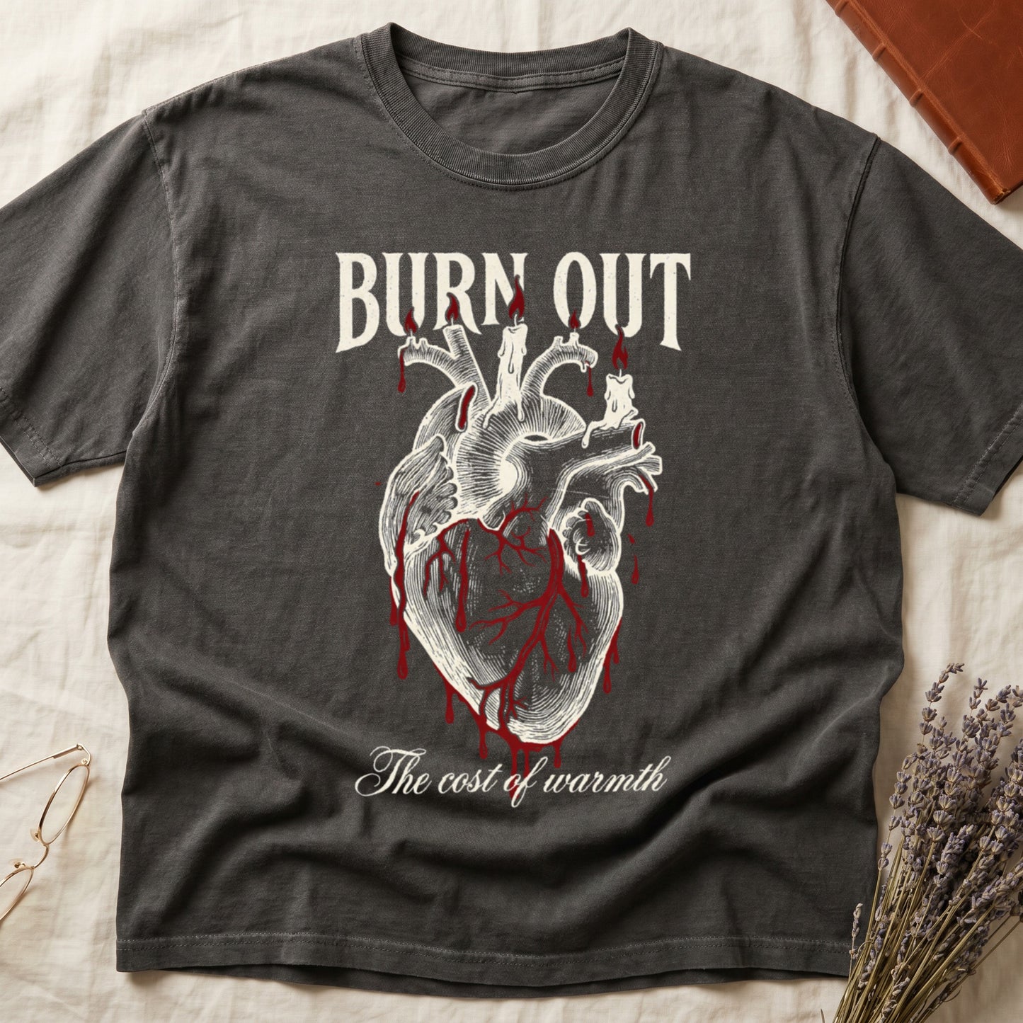 Pepper tee with anatomical heart and melted candles dripping red wax, "BURN OUT" top, "The cost of warmth" cursive below.
