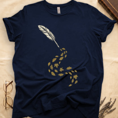 Navy tee with antique quill pen in cream linework, oak and maple leaves cascading from the nib in gold and green.