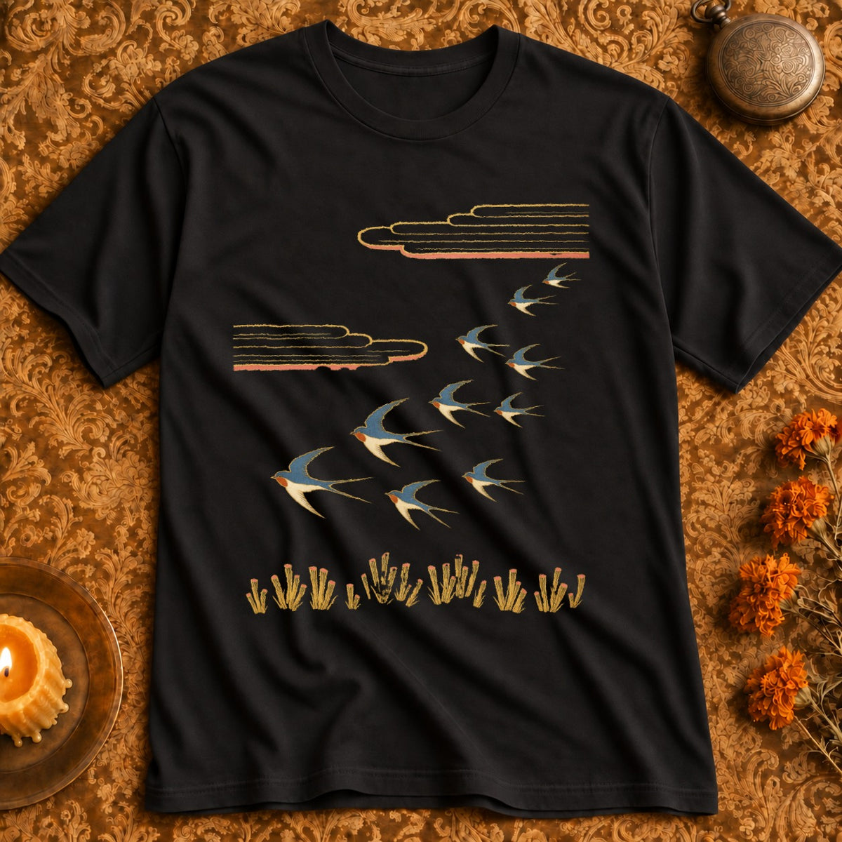 Black t-shirt with a flock of swallows flying past stylized clouds and grass.