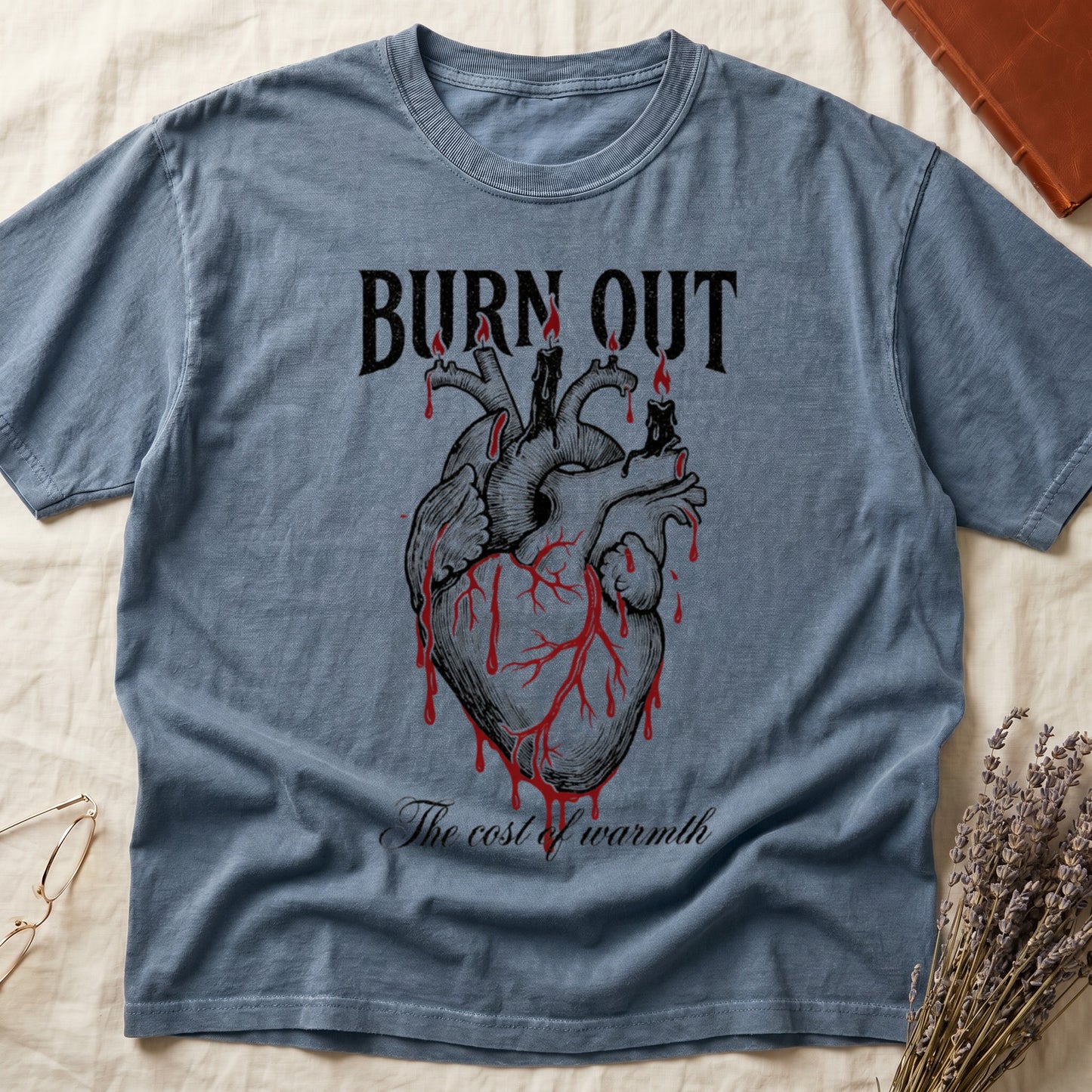 Blue Jean tee with anatomical heart and melted candles dripping red wax, "BURN OUT" top, "The cost of warmth" cursive below.