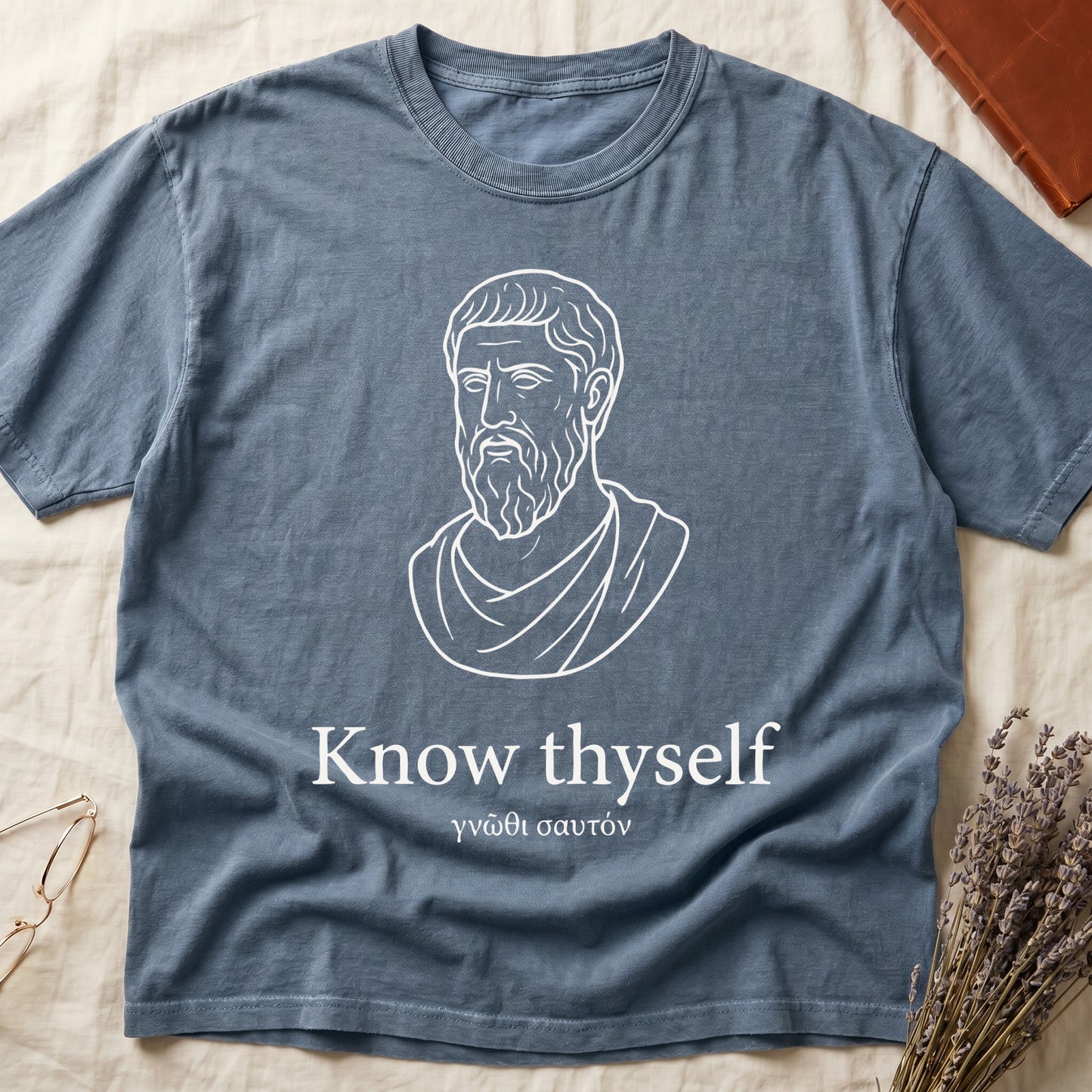 Blue Jean tee with classical Greek philosopher bust in white linework, "Know thyself" in cream serif below.