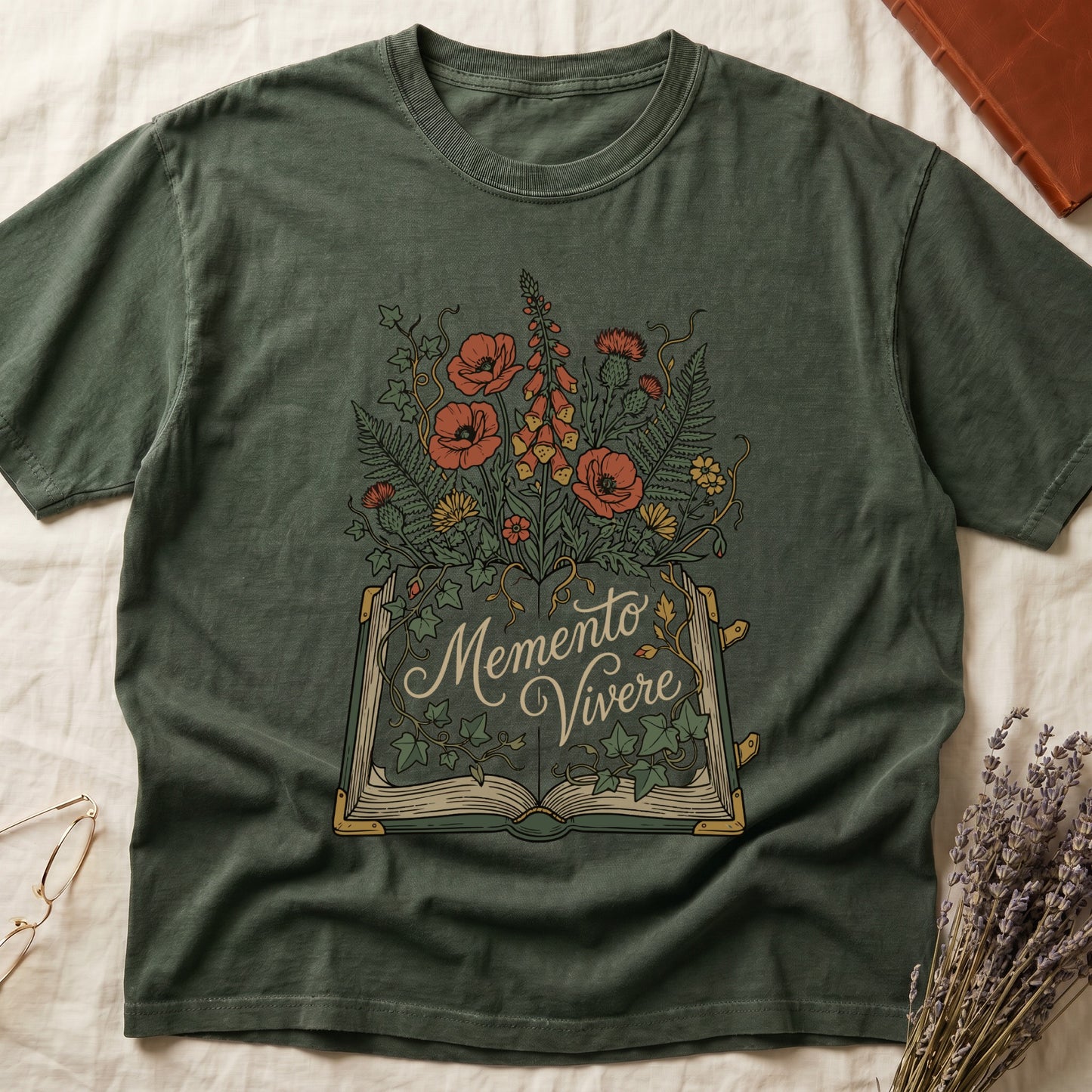 Green tee with open book and botanical illustration, red poppies, golden foxglove, ferns and ivy spilling from the pages.