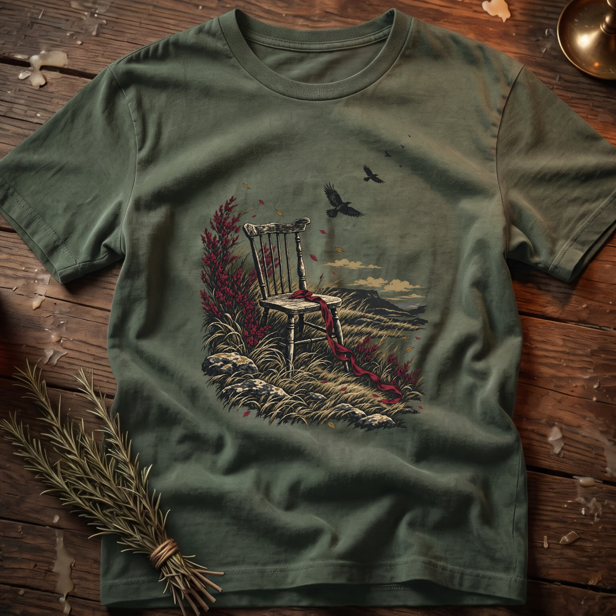 Green t-shirt with a vintage illustration of an empty chair in a grassy landscape with birds.