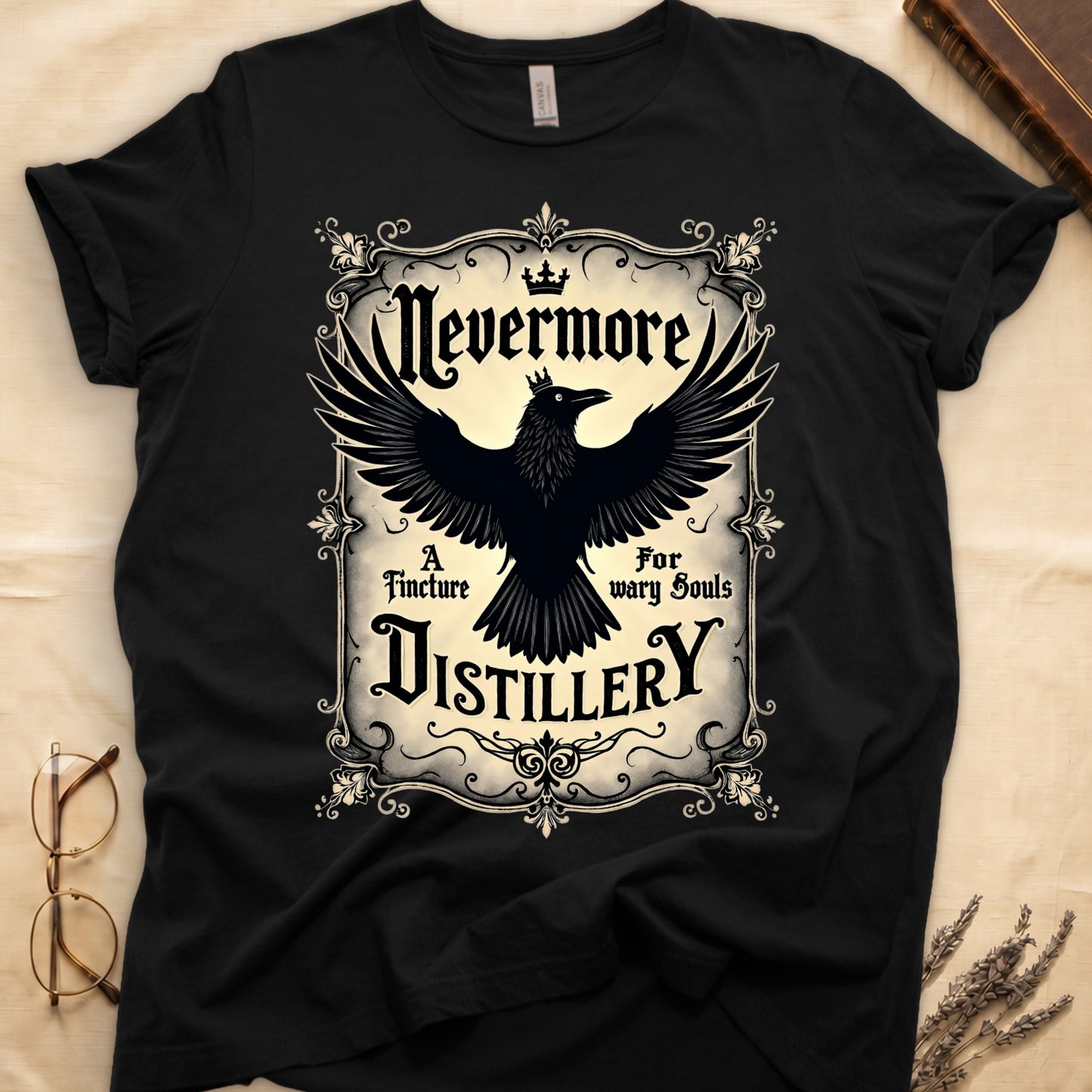 Black tee with antique label, crowned raven, blackletter "Nevermore" top, "A Tincture For wary Souls," "DISTILLERY" bottom.