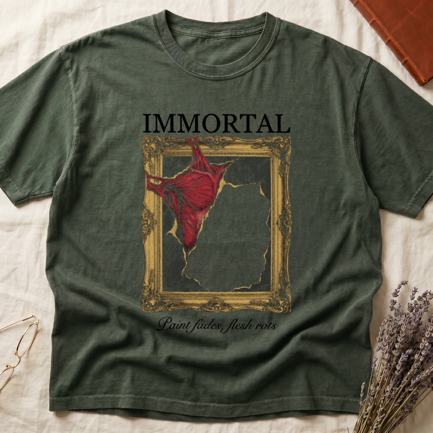 Green tee with gold frame and exposed muscle tearing canvas, "IMMORTAL" top, "Paint fades, flesh rots" italic below.