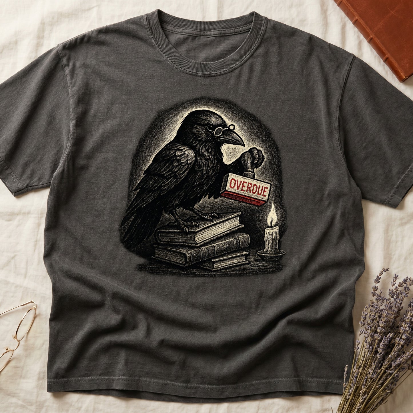 Pepper tee with bespectacled raven on stacked books, holding wooden "OVERDUE" stamp, lit candle beside, dawn glow behind.