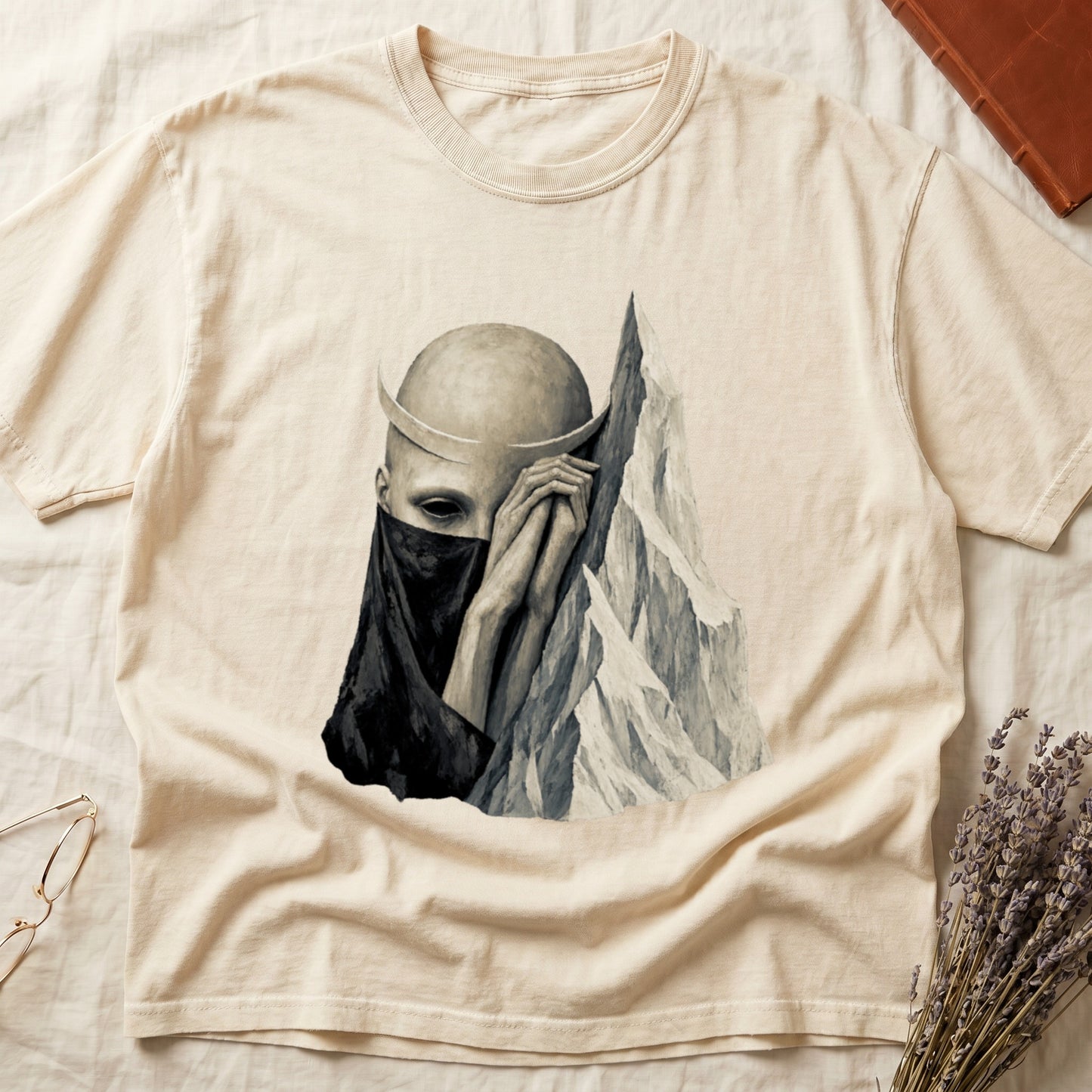 Light beige t-shirt with a monochrome graphic of a shadowed figure with a horn next to a mountain.