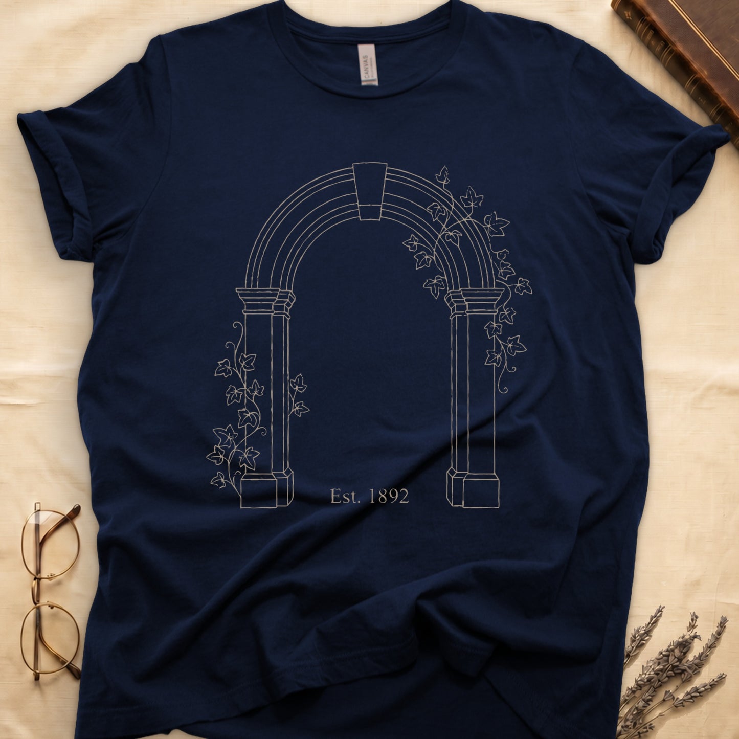 Navy tee with Gothic stone archway in cream linework, ivy climbing the columns, "Est. 1892" inscribed at the base.