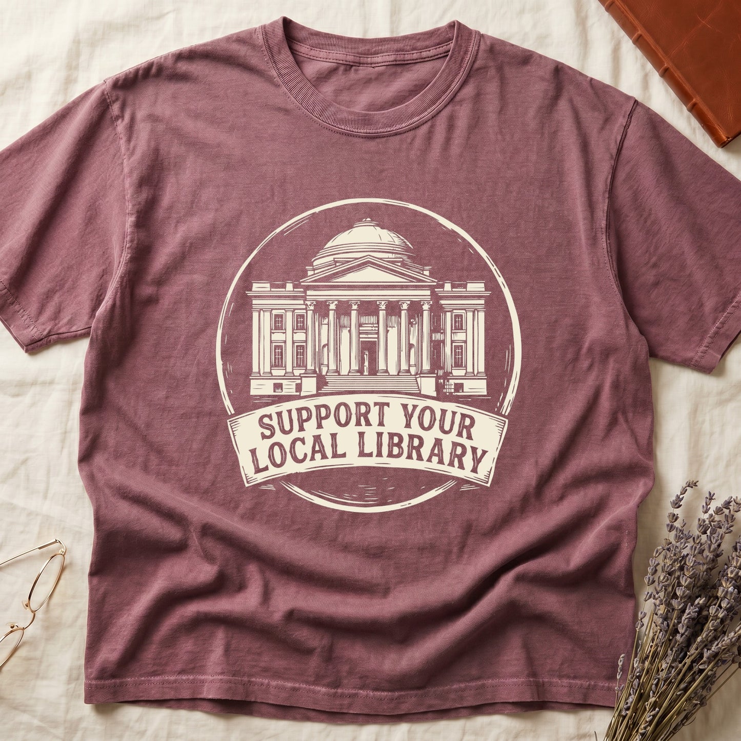 Dark Rose tee with circular cream badge of a classical library building, "SUPPORT YOUR LOCAL LIBRARY" on a banner below.