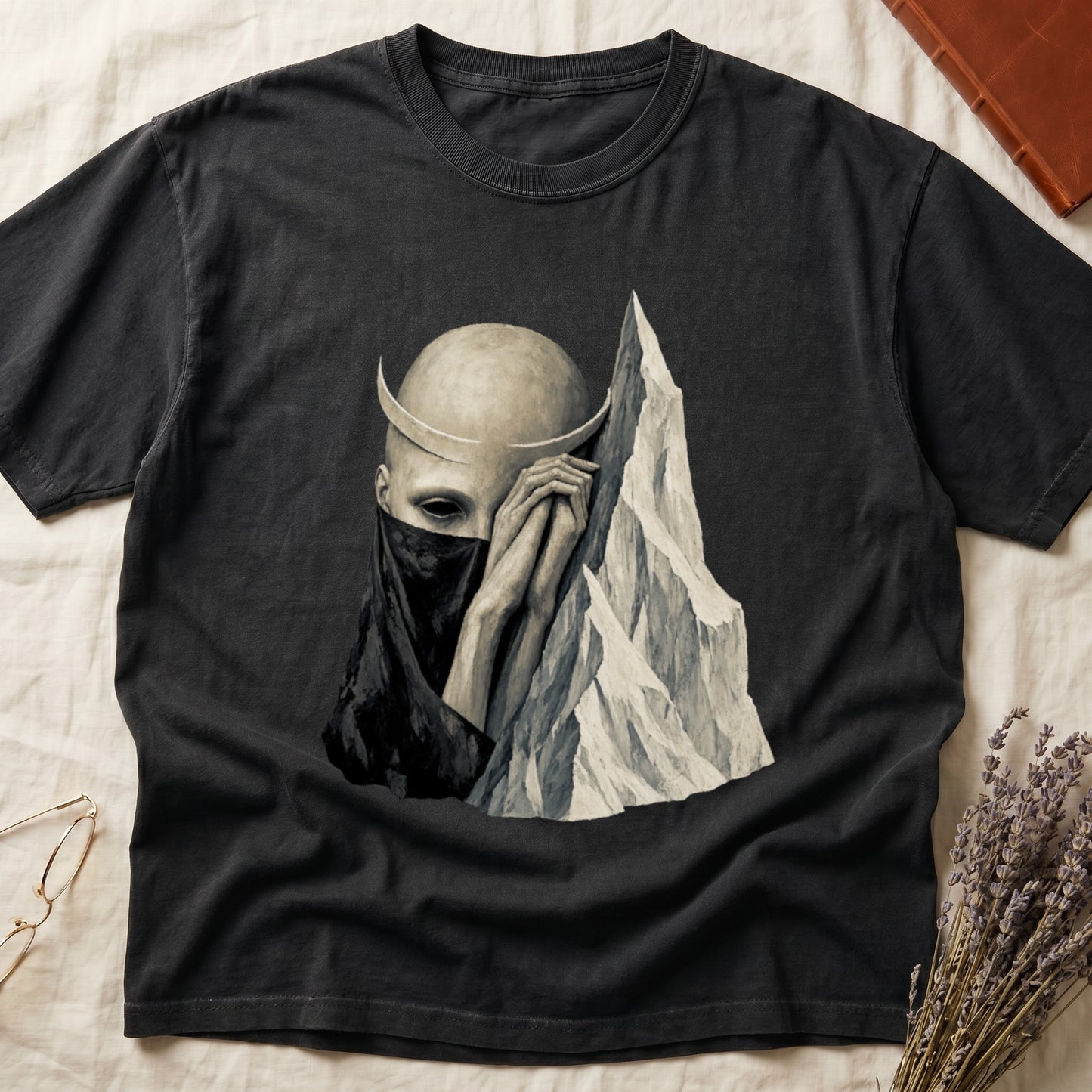 Black t-shirt with a gothic art print of a figure with horns and a veil beside a mountain.
