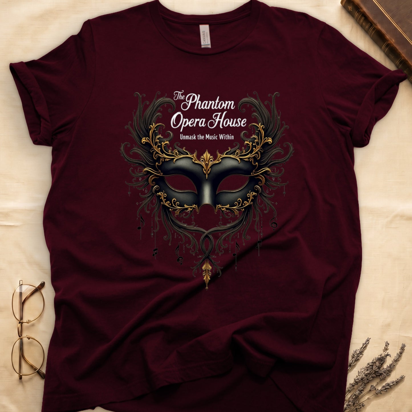 Maroon tee with gold-and-black masquerade mask, scrollwork wings, "The Phantom Opera House," "Unmask the Music Within."