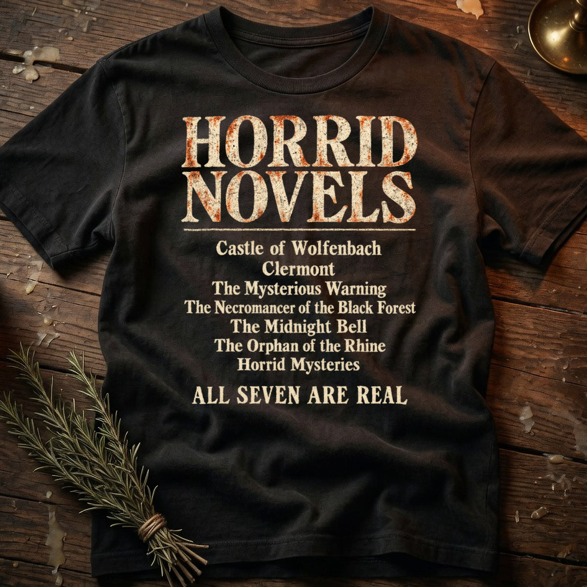 Black t-shirt with "HORRID NOVELS" and a list of titles, ending with "ALL SEVEN ARE REAL".