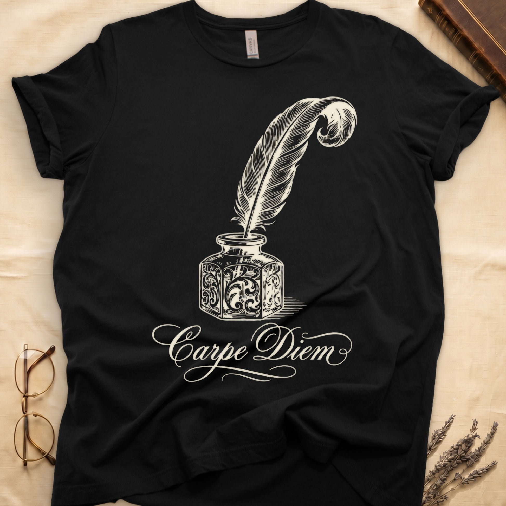 Black tee with ornate antique inkwell and quill pen in sepia linework, "Carpe Diem" in flowing cursive below.