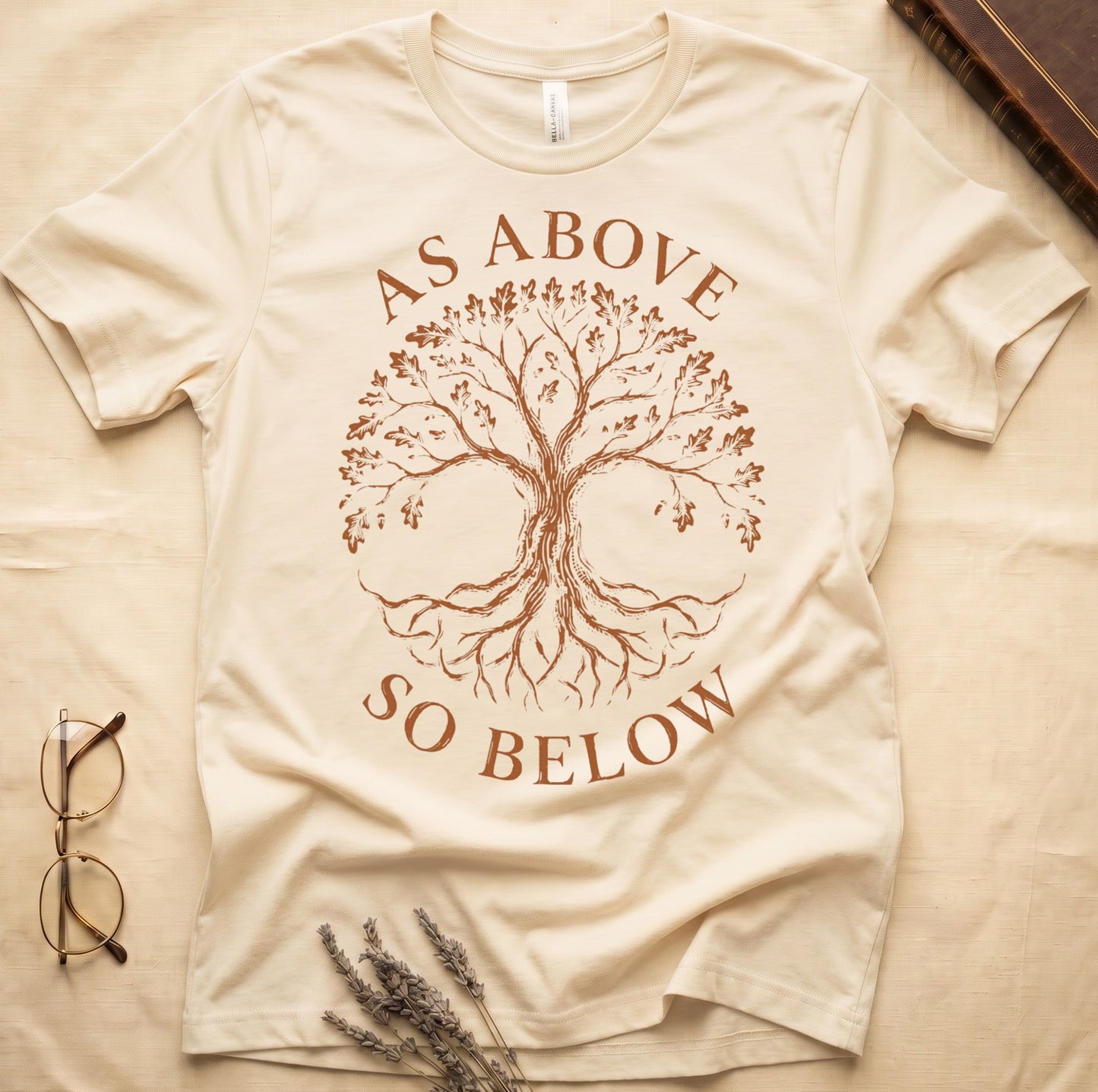 Natural tee with Tree of Life in cream linework, mirrored canopy and roots, "AS ABOVE" and "SO BELOW" in serif arcs.