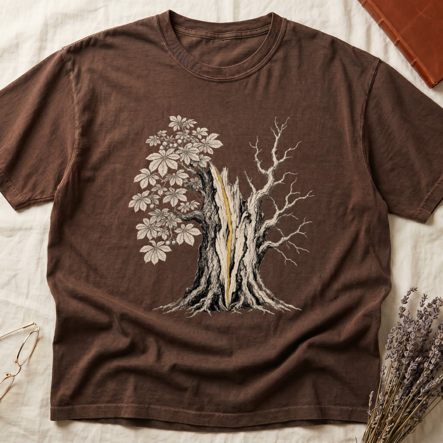 Brown t-shirt with graphic of a split tree, one side with leaves, the other bare.