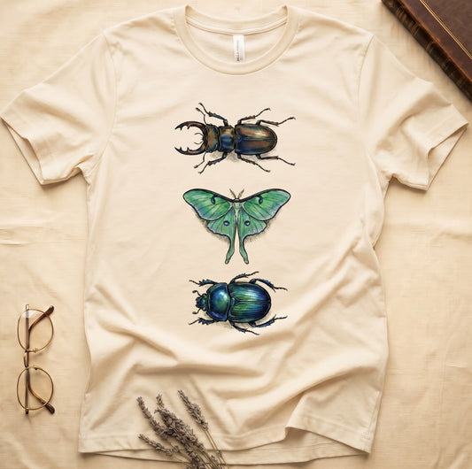 Black tee with three-panel Natural-history plate: stag beetle, luna moth, scarab beetle in ink on yellow ground.