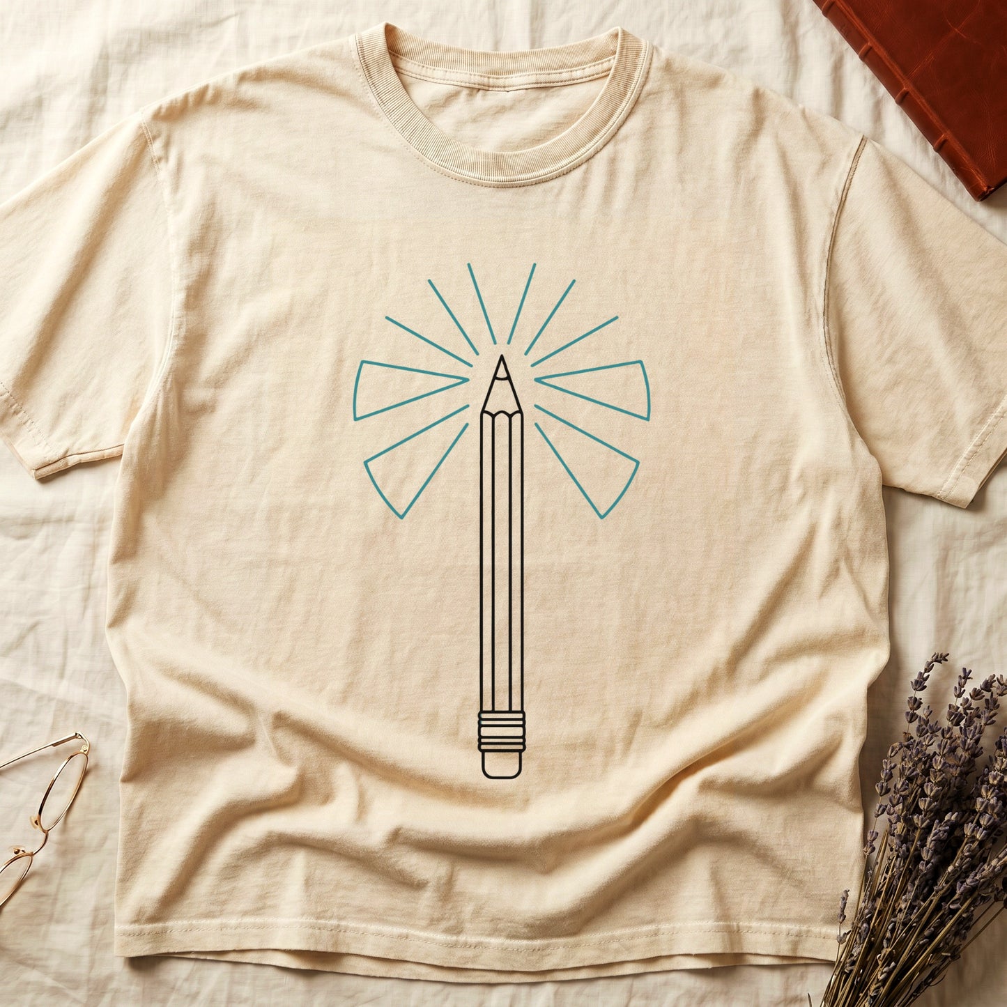 Ivory tee with single vertical graphite pencil in cream linework, fan of teal and grey rays radiating behind.