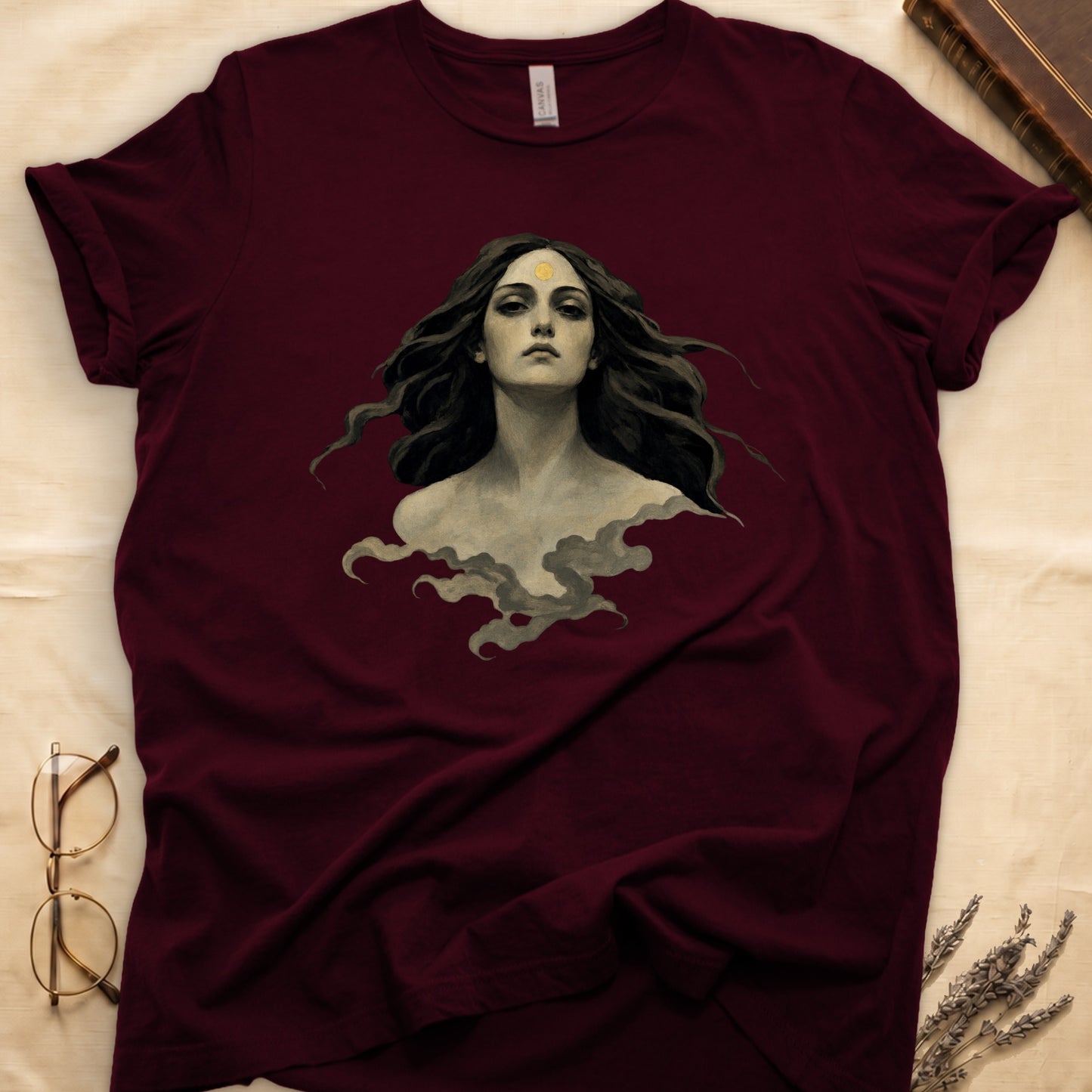 Maroon t-shirt with artwork of a woman with a sun symbol on her forehead.