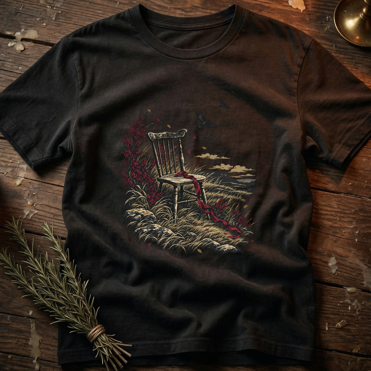 T-shirt with a dark t-shirt featuring a graphic of an empty chair on a grassy hill with red ribbon.