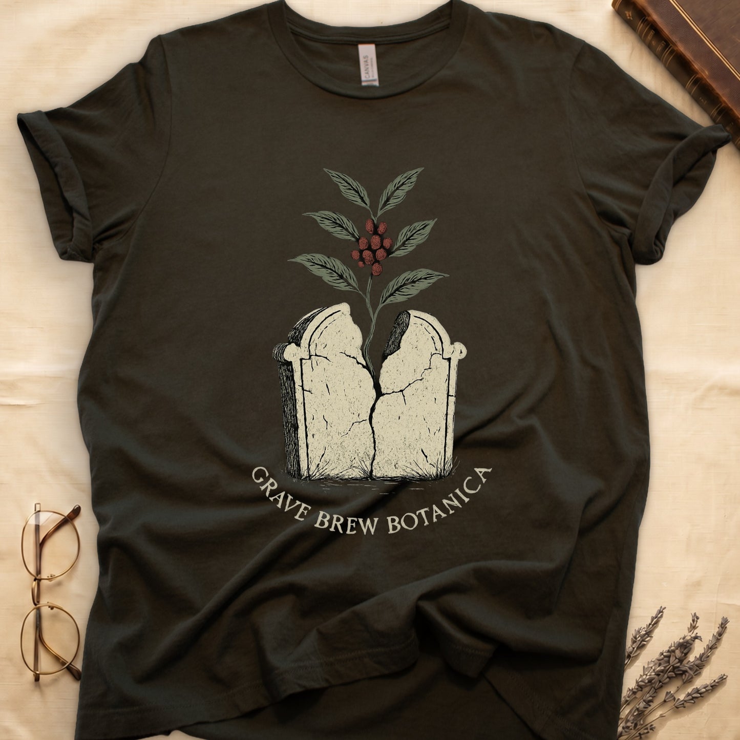 Dark t-shirt with cracking tombstone graphic, coffee plant growing, and "Grave Brew Botanica" text.