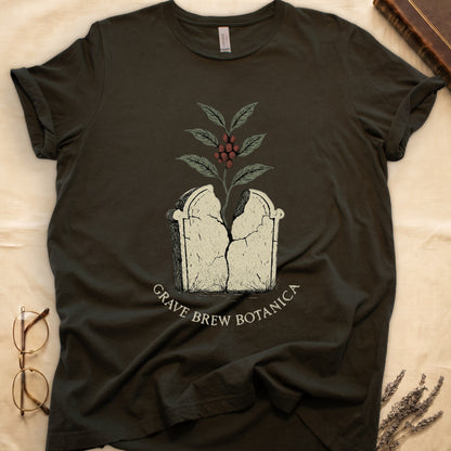 Dark t-shirt with cracking tombstone graphic, coffee plant growing, and "Grave Brew Botanica" text.