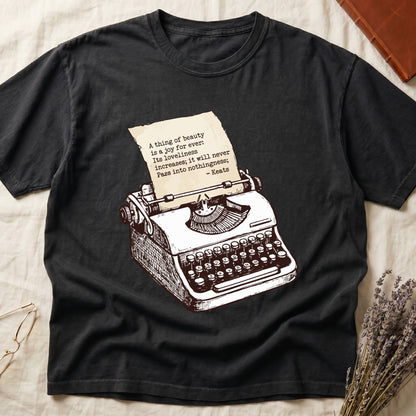 Black tee with vintage typewriter in cream linework, paper showing "A thing of beauty is a joy for ever" by Keats.