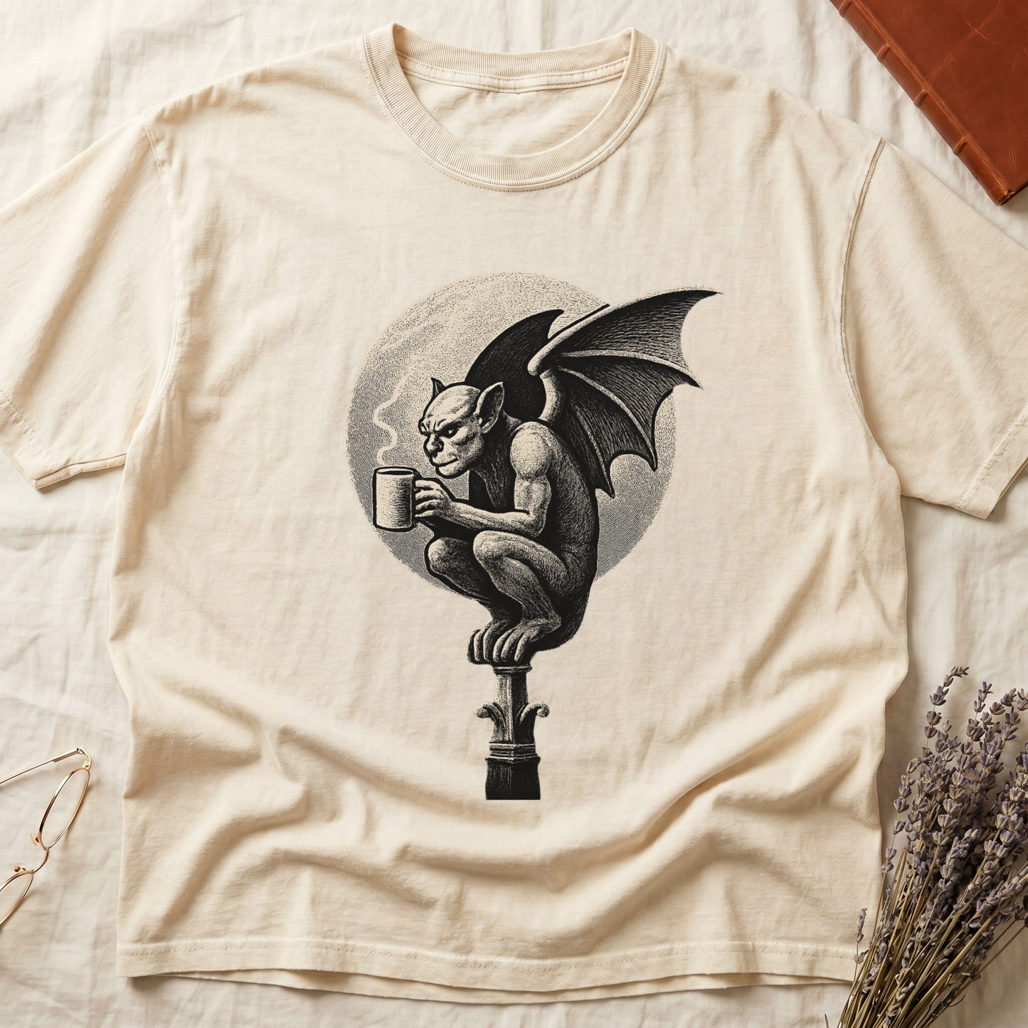 Ivory tee with gargoyle on stone pinnacle holding coffee mug, cream-parchment full moon behind, engraving style.