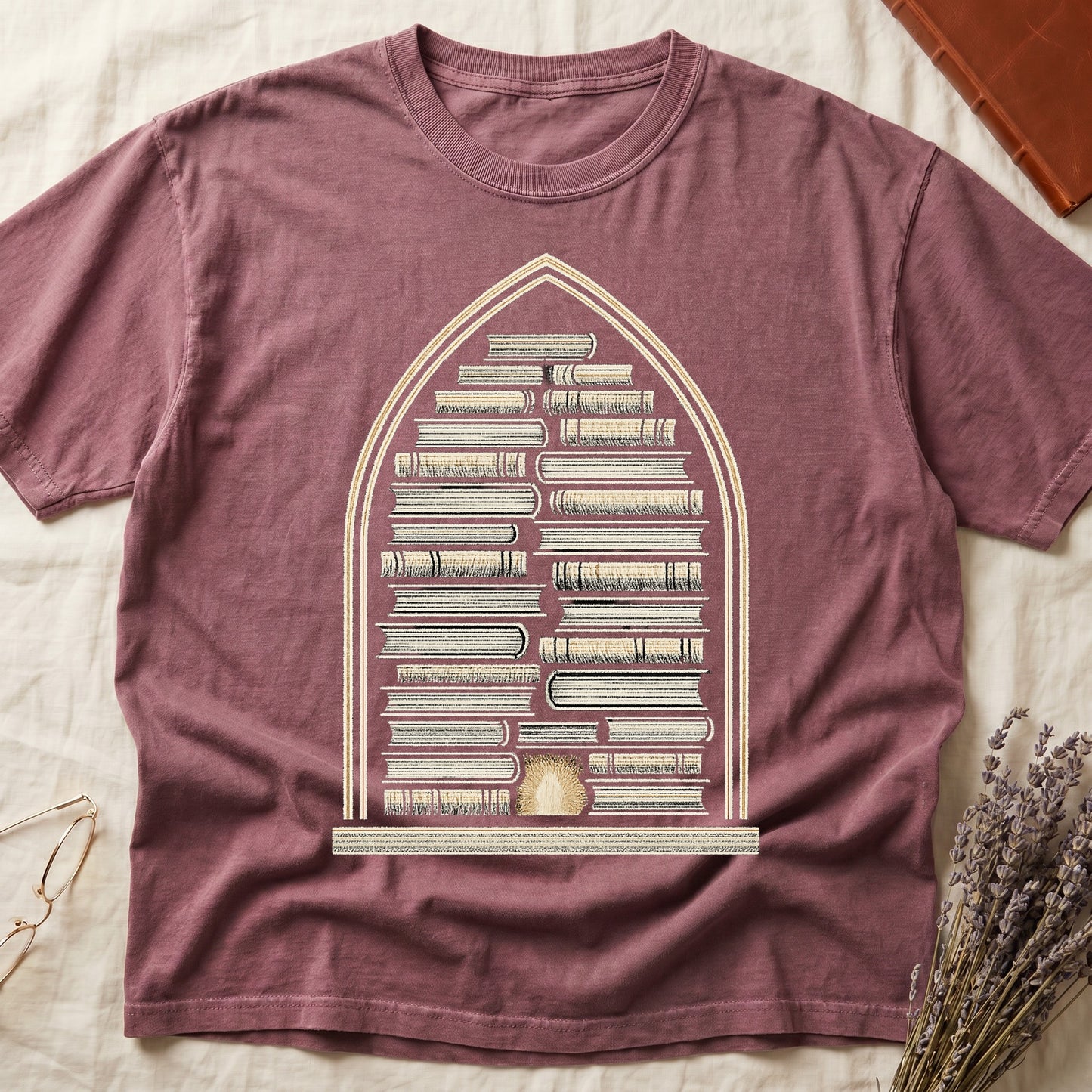 Dark Rose tee with gothic arch frame, columns of leather-bound books inside, sunburst medallion at base, cream engraved linework.