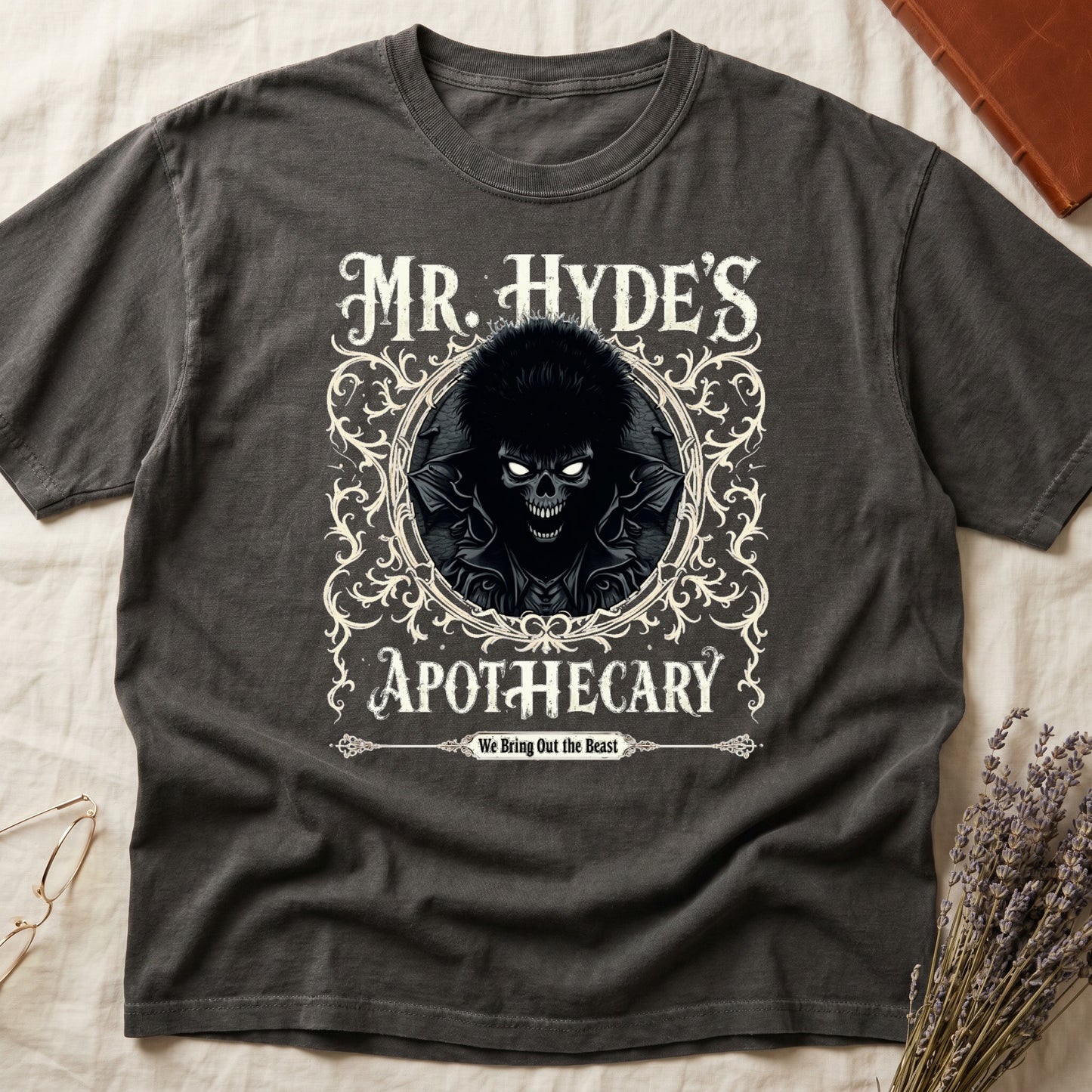 Green tee with ornate filigree frame, wild-haired skull figure, "MR. HYDE'S APOTECARY," "We Bring Out the Beast" below.