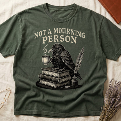 Dark Rose tee with raven holding coffee on stack of books, quill in inkwell, "NOT A MOURNING PERSON" distressed serif top.