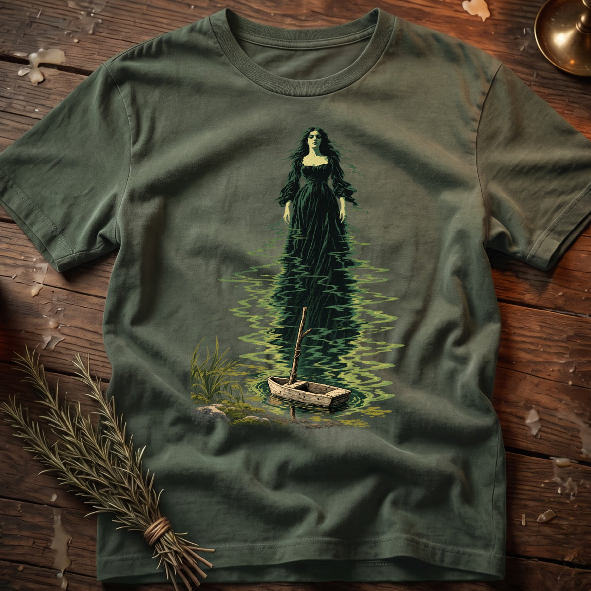 Green t-shirt with dark illustration of a woman in a long dress in water, near a boat.