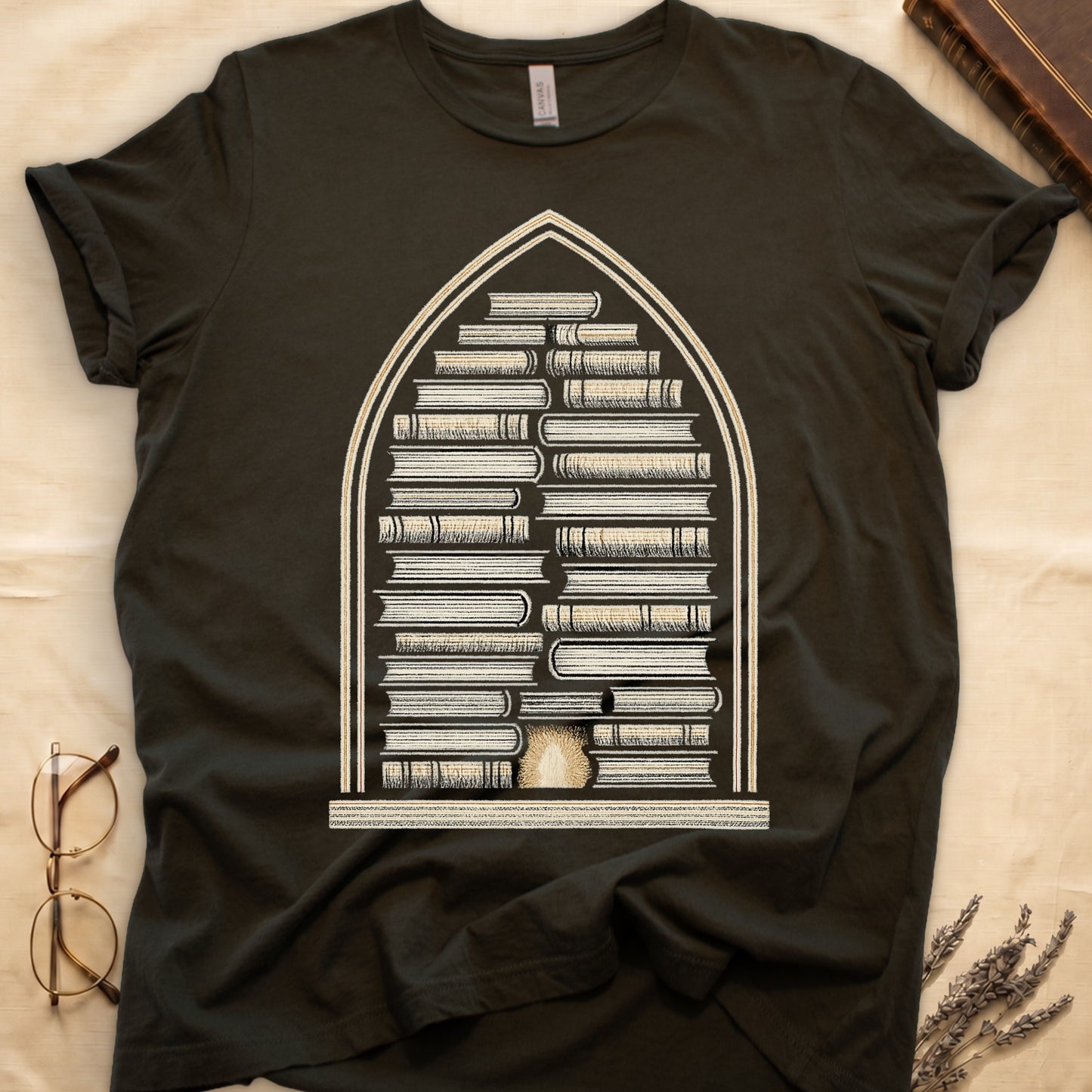 Military Green tee with gothic arch frame, columns of leather-bound books inside, sunburst medallion at base, cream engraved linework.