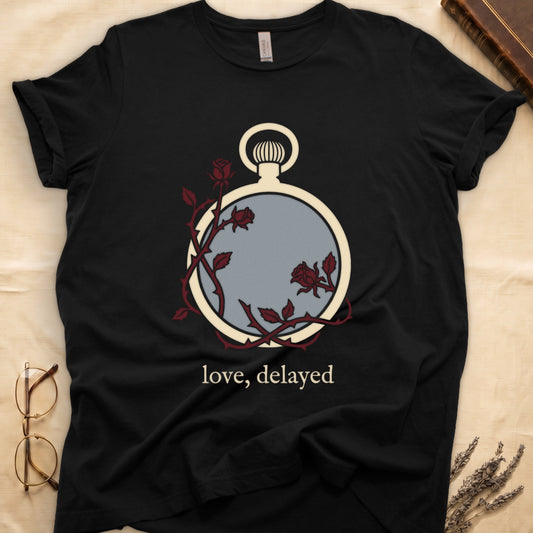 Black tee with vintage cream pocket watch and dark red roses entwined, "love, delayed" in cream serif below.