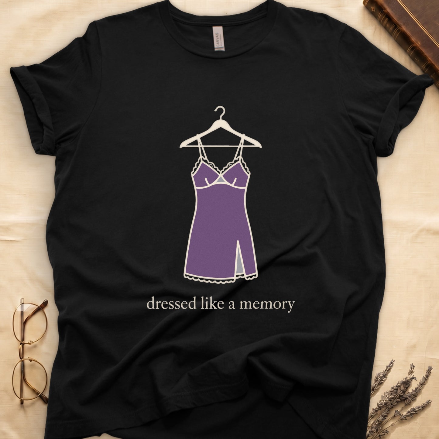 Black tee with dusty plum slip dress on cream hanger and "dressed like a memory" in lowercase cream serif below.