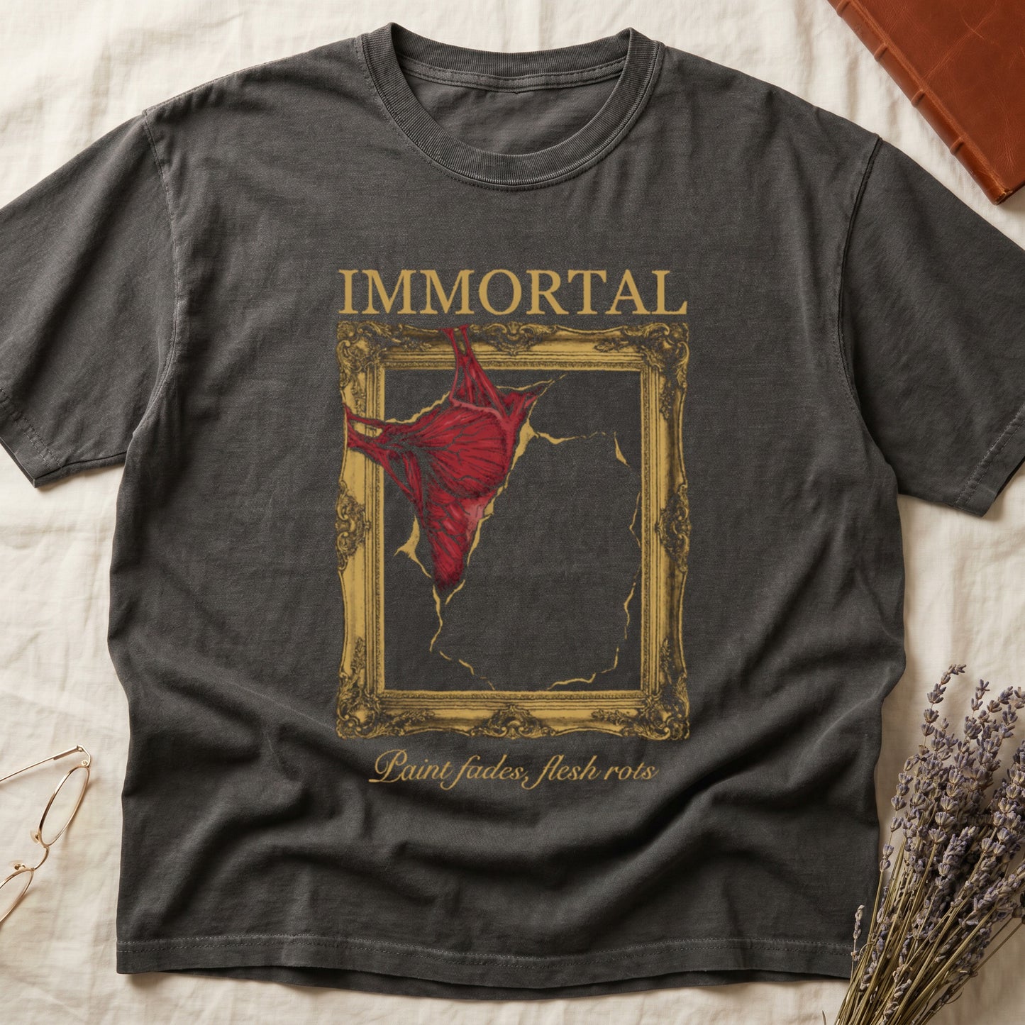 Pepper tee with gold frame and exposed muscle tearing canvas, "IMMORTAL" top, "Paint fades, flesh rots" italic below.