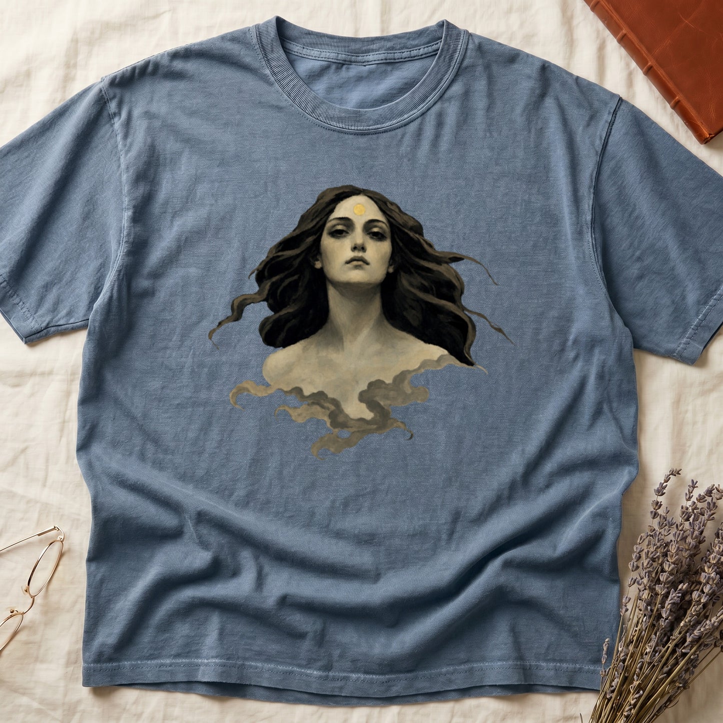 Blue t-shirt with painted portrait of a woman with dark hair and a golden mark on her forehead.
