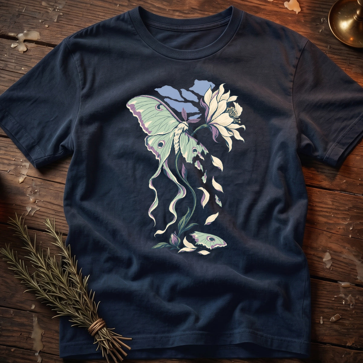Dark blue t-shirt with luna moth and flower graphic, scattered petals and leaves.