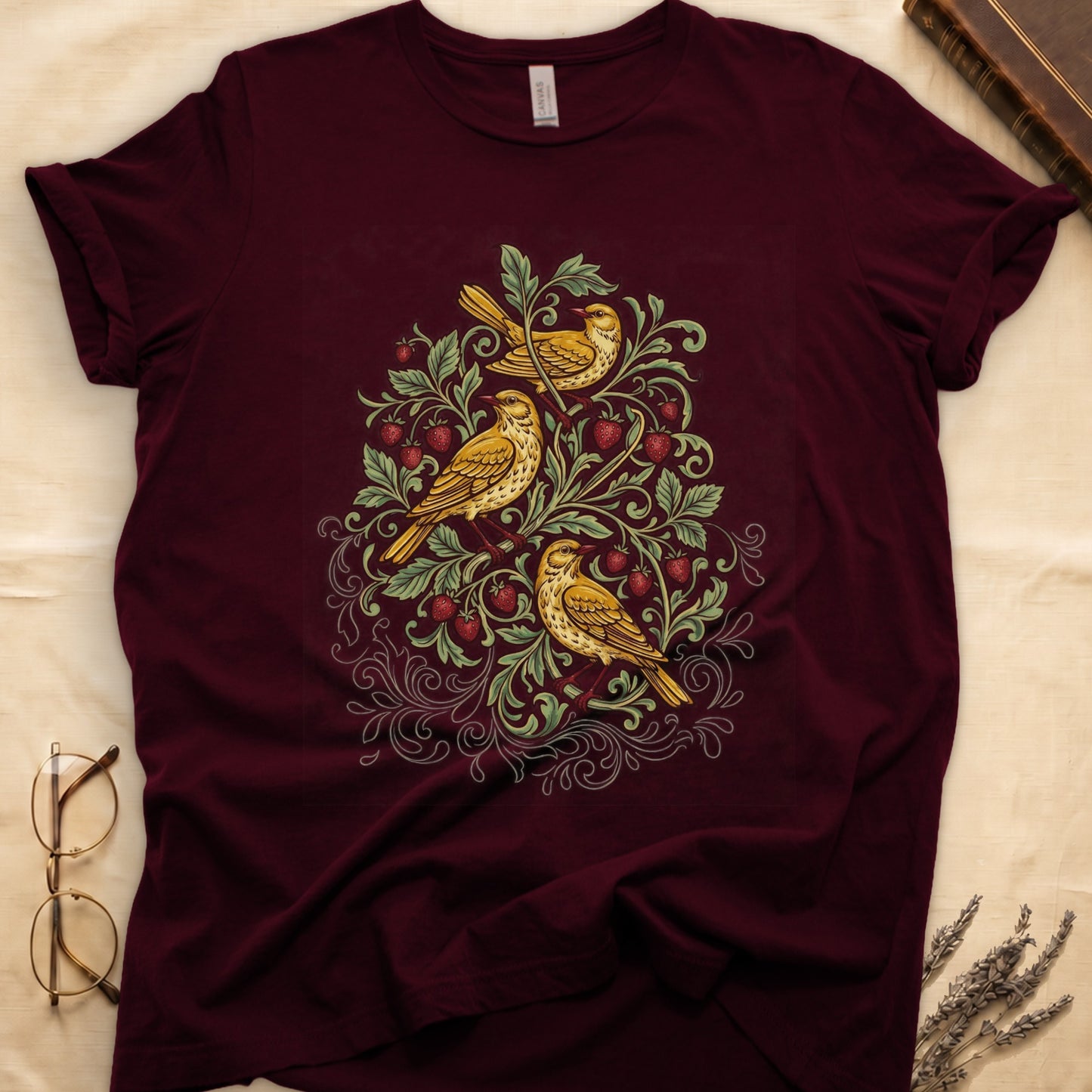 Maroon tee with three yellow songbirds perched among strawberry vines and green leaves, William Morris pattern style.